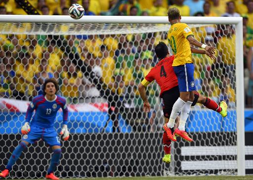 Brazil's forward Neymar (R) and Mexico's defender Rafael Marquez (C) jump for the ball in front of Mexico's goalkeeper Guillermo Ochoa during a World Cup match in Fortaleza on June 17, 2014